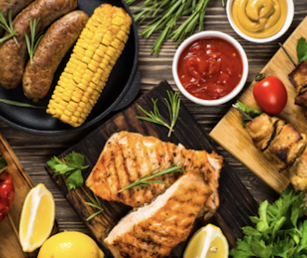 Corn, fish and other food spread out on table